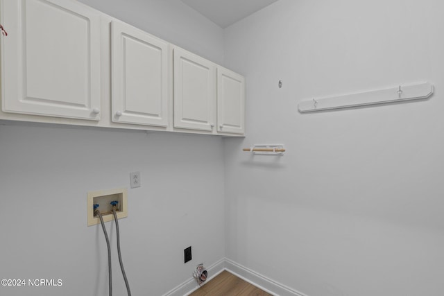 clothes washing area featuring cabinets, hardwood / wood-style floors, gas dryer hookup, and hookup for a washing machine