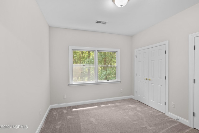 unfurnished bedroom with carpet and a closet