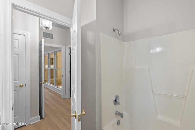 bathroom with shower / bath combination and hardwood / wood-style flooring