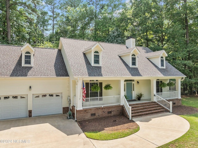 cape cod-style house featuring covered porch and a garage