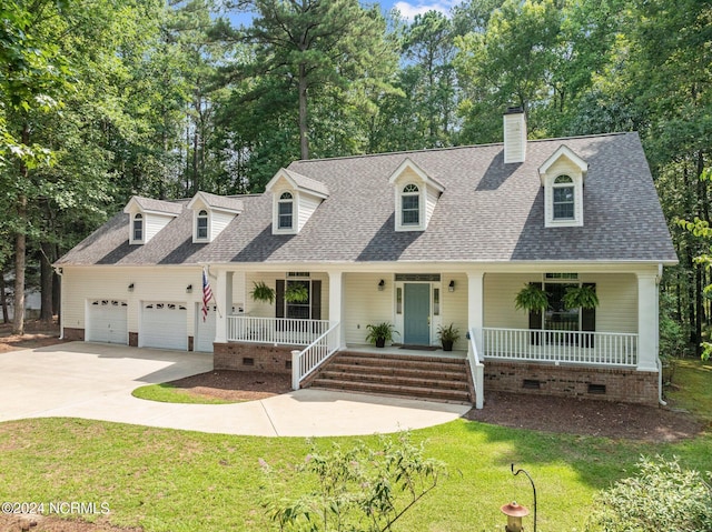 new england style home featuring a front lawn, covered porch, and a garage