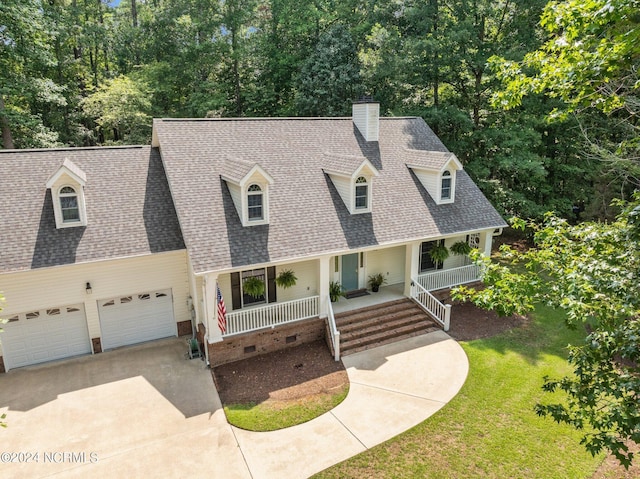 cape cod house with a front lawn, covered porch, and a garage