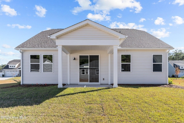 rear view of house featuring a yard