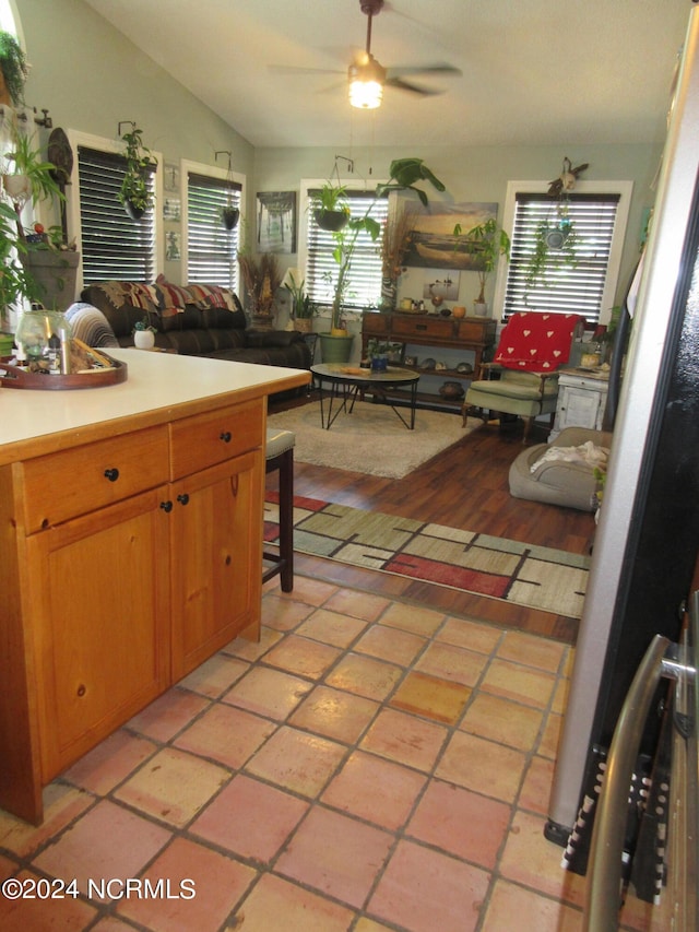 kitchen with light tile patterned floors, ceiling fan, and vaulted ceiling