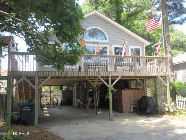 back of property featuring a carport and a deck