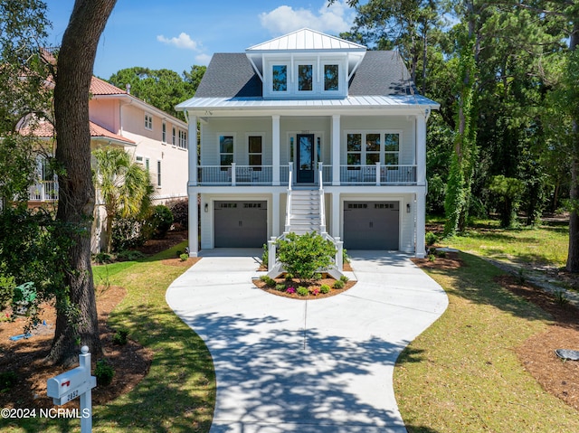 view of front of property with covered porch, a garage, and a front lawn