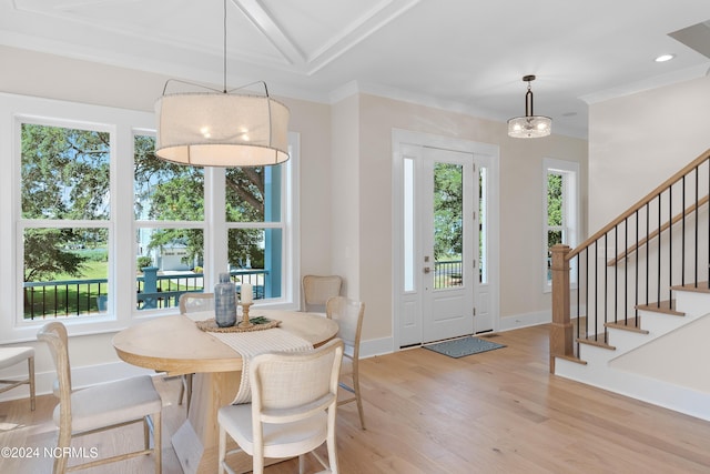 dining area with light hardwood / wood-style floors and ornamental molding