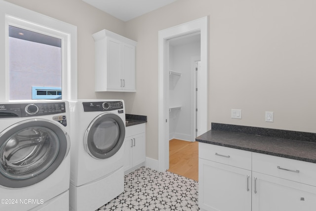 laundry area with washing machine and dryer and cabinets