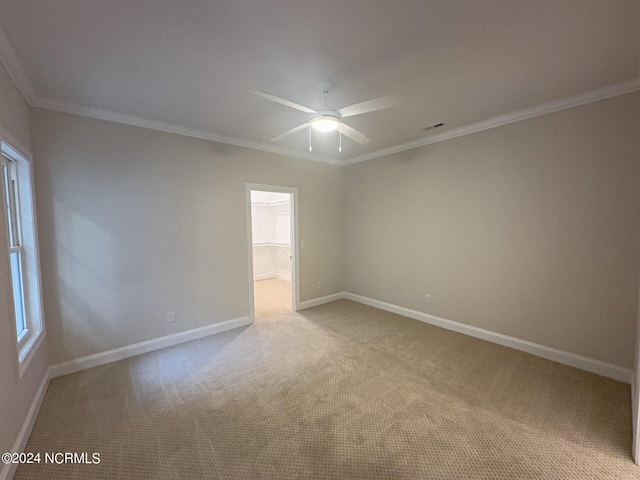 carpeted empty room featuring ceiling fan and crown molding