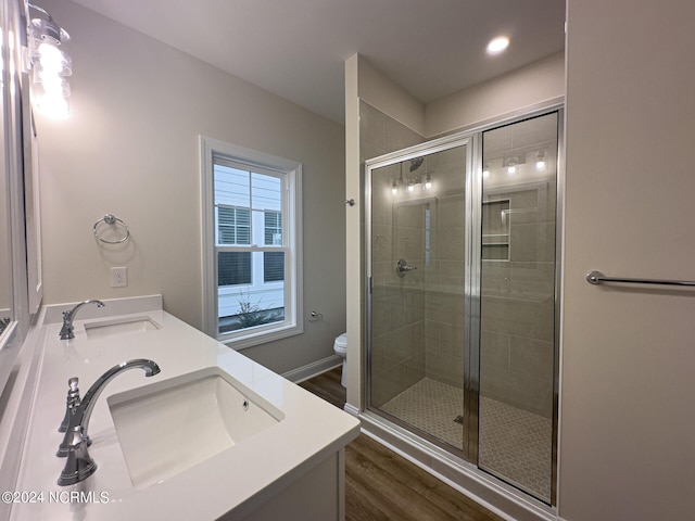 bathroom featuring toilet, walk in shower, hardwood / wood-style flooring, and vanity