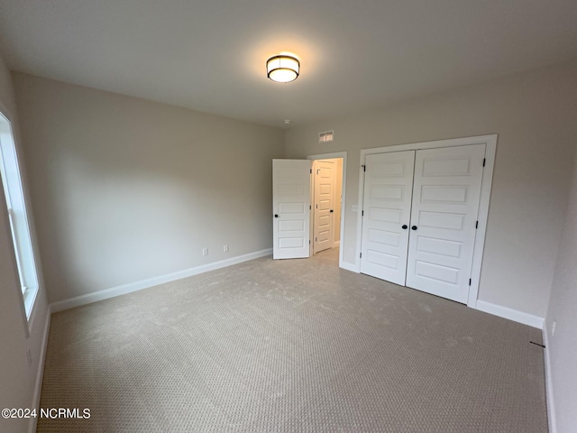 unfurnished bedroom with a closet and carpet floors