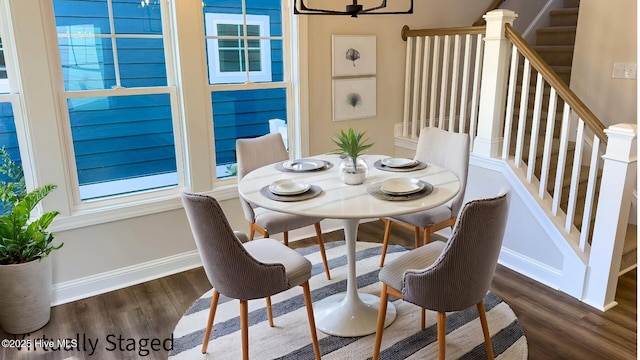 dining room with dark hardwood / wood-style floors and a notable chandelier