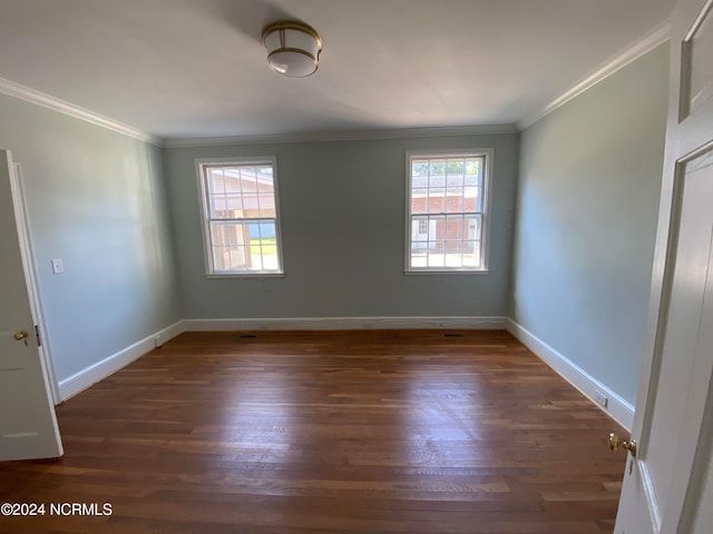 empty room featuring ornamental molding and dark hardwood / wood-style flooring