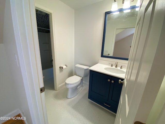 bathroom with toilet, vanity, and tile patterned floors