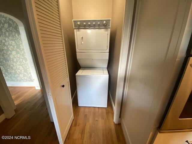 laundry room featuring light hardwood / wood-style flooring and stacked washer / dryer