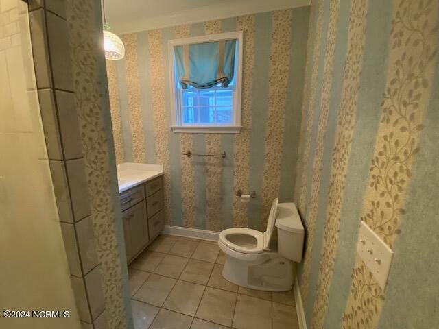 bathroom featuring vanity, crown molding, toilet, and tile patterned floors