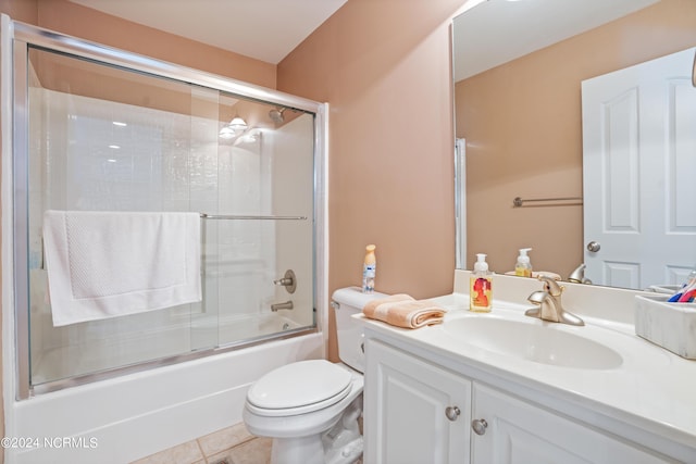 bathroom with toilet, vanity, bath / shower combo with glass door, and tile patterned floors