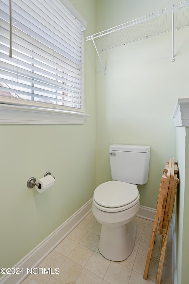 bathroom featuring toilet, radiator, baseboards, and tile patterned floors