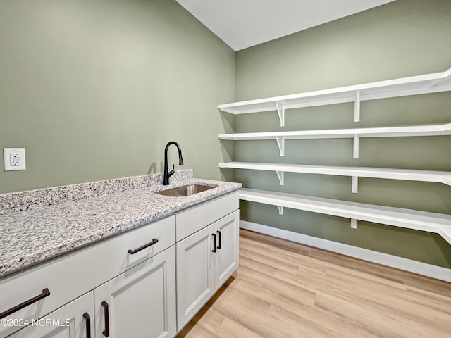 washroom featuring light wood finished floors and a sink