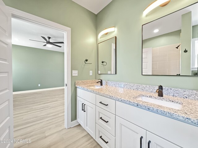 bathroom with double sink vanity, hardwood / wood-style floors, and ceiling fan