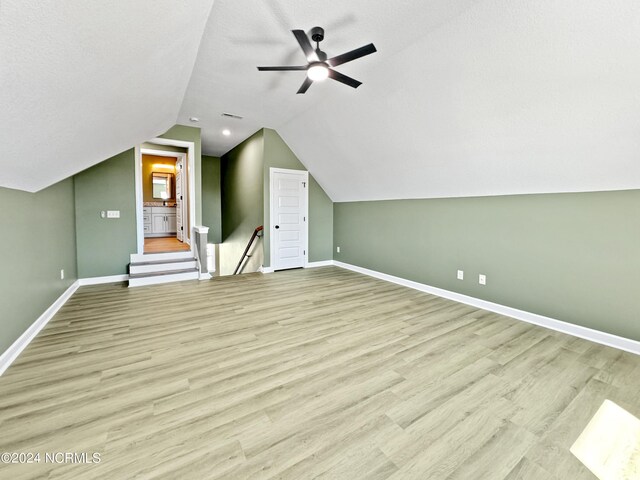 bonus room featuring a textured ceiling, wood-type flooring, ceiling fan, and vaulted ceiling