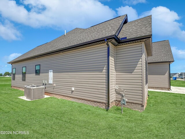 view of home's exterior featuring a yard and central AC