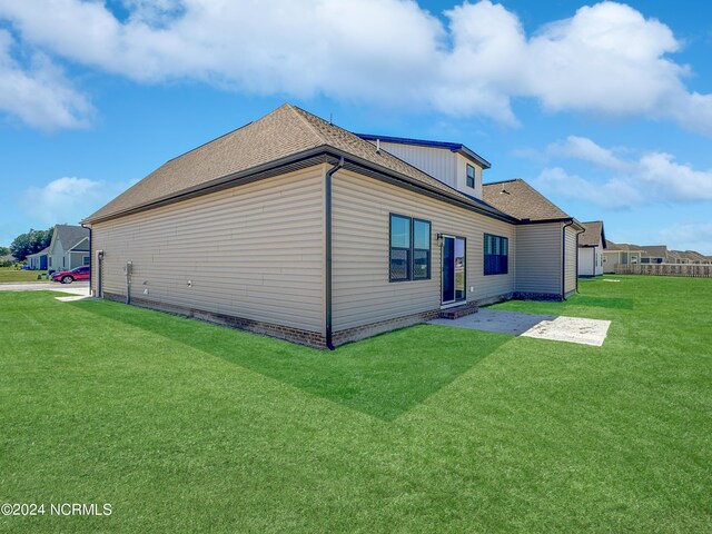 back of property with a patio area and a yard