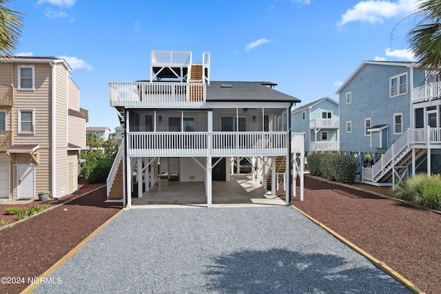 view of front of home with a carport and a sunroom