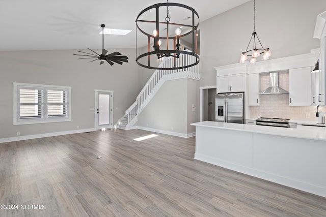 kitchen featuring white cabinets, backsplash, wall chimney range hood, and stainless steel appliances