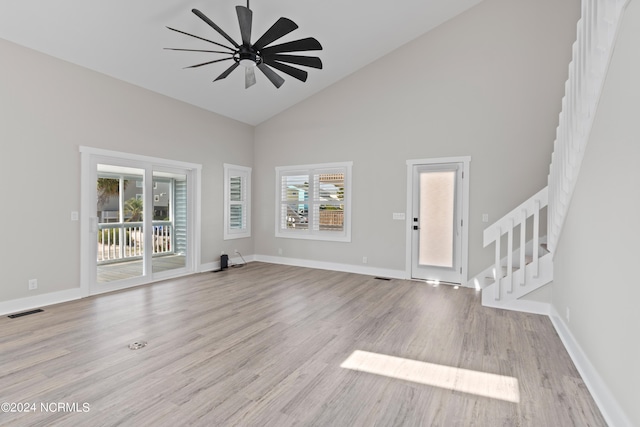 unfurnished living room with ceiling fan, light hardwood / wood-style floors, and high vaulted ceiling