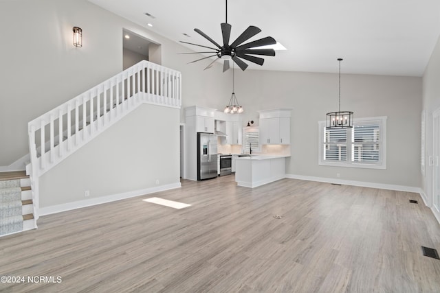 unfurnished living room with ceiling fan, light hardwood / wood-style flooring, high vaulted ceiling, and sink