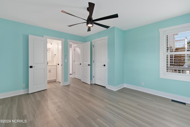 unfurnished bedroom featuring light hardwood / wood-style floors, ensuite bath, and ceiling fan