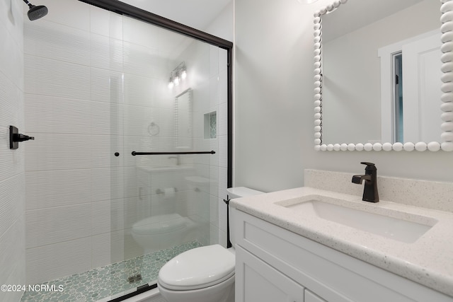 bathroom featuring vanity, toilet, and an enclosed shower