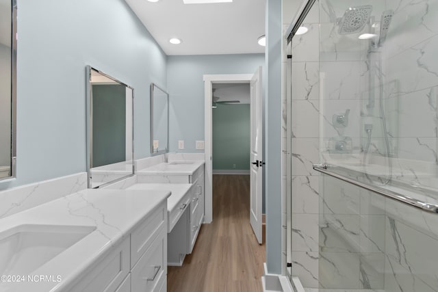 bathroom with hardwood / wood-style floors, vanity, and a shower with shower door