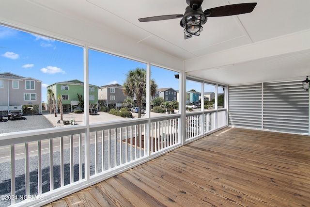 unfurnished sunroom with ceiling fan