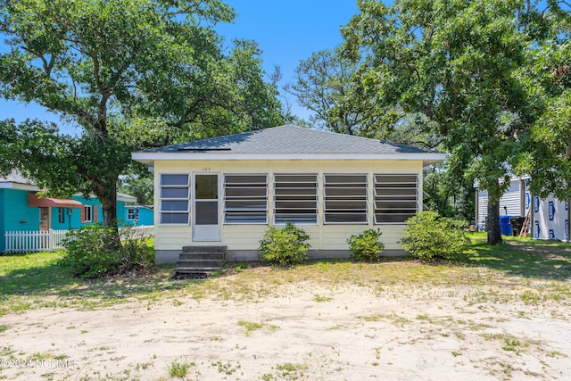 back of property with entry steps and a shingled roof