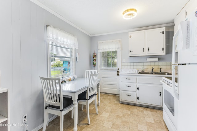 kitchen with white cabinetry, light countertops, a wealth of natural light, and range with electric stovetop