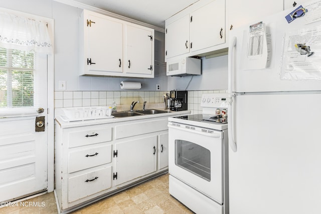 kitchen featuring white appliances, decorative backsplash, light countertops, white cabinetry, and a sink