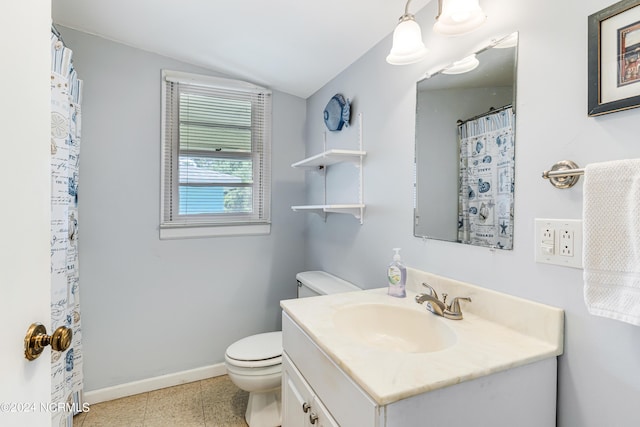 bathroom with toilet, vanity, baseboards, vaulted ceiling, and tile patterned floors