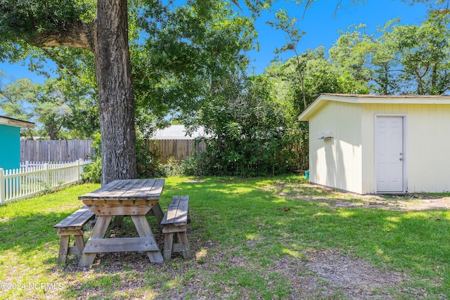 view of yard with a fenced backyard, an outdoor structure, and a storage shed