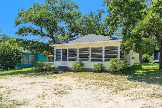 rear view of property with entry steps and a sunroom