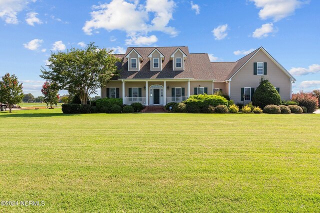 cape cod house featuring a porch and a front lawn