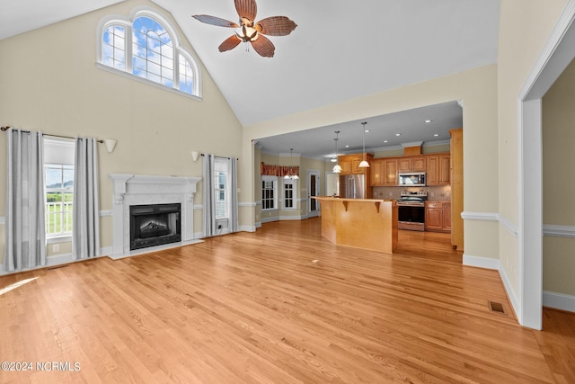 unfurnished living room featuring a fireplace, visible vents, plenty of natural light, and light wood finished floors