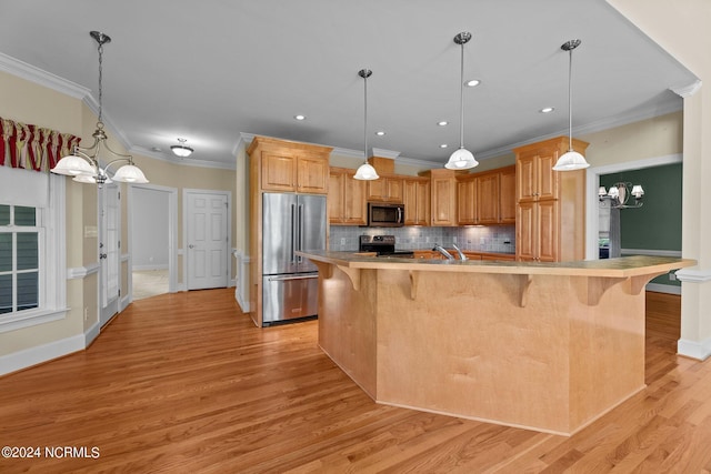 kitchen with appliances with stainless steel finishes, a breakfast bar, light wood-style floors, and backsplash