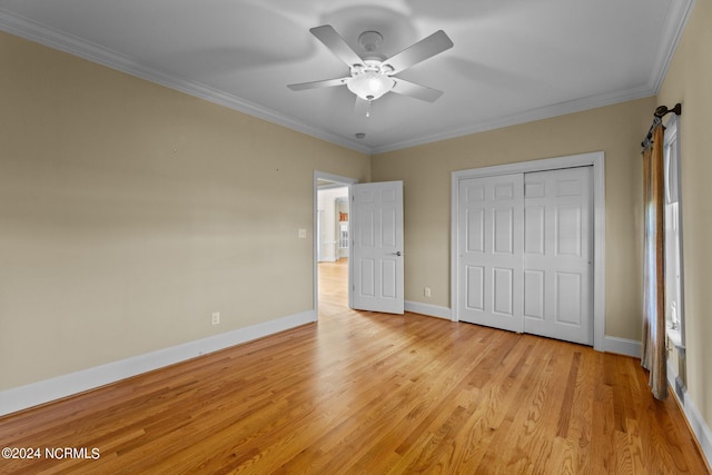 unfurnished bedroom featuring a ceiling fan, baseboards, a closet, light wood finished floors, and crown molding