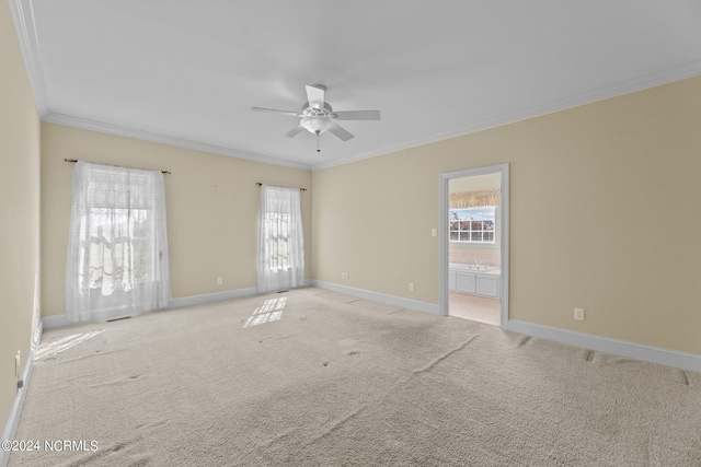 unfurnished room featuring light colored carpet, crown molding, and baseboards