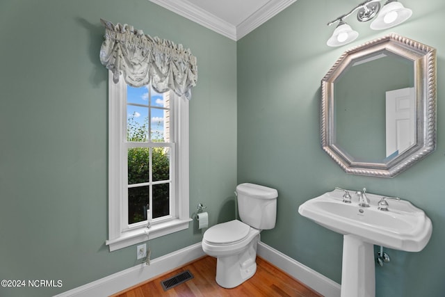 bathroom featuring visible vents, toilet, ornamental molding, wood finished floors, and baseboards