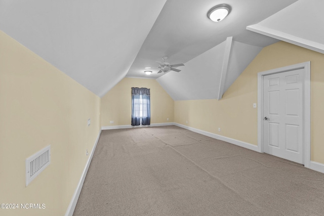 additional living space featuring a ceiling fan, visible vents, vaulted ceiling, baseboards, and carpet