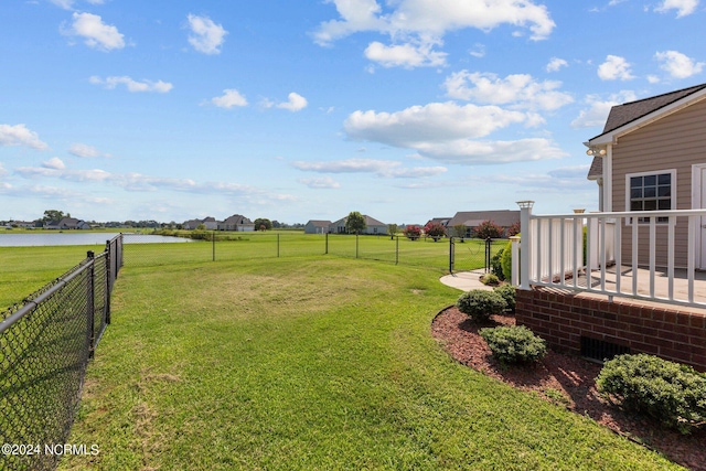 view of yard featuring a water view and fence