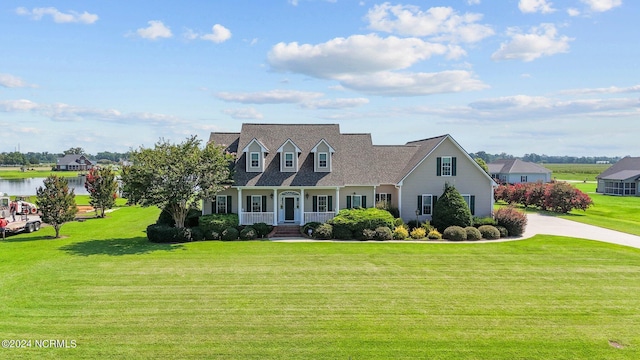 cape cod home with a water view and a front yard